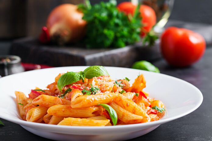 Classic italian pasta penne alla arrabiata with basil and freshly grated parmesan cheese